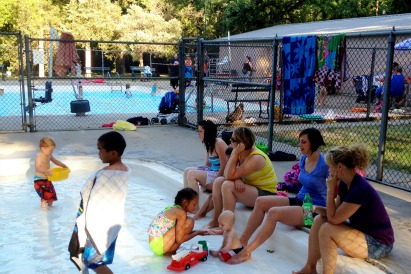Moms and kids cool off in the wading pool.